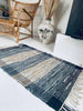 Gulvteppe i flettet skinn – 60x90cm Grå/blå med sølv
